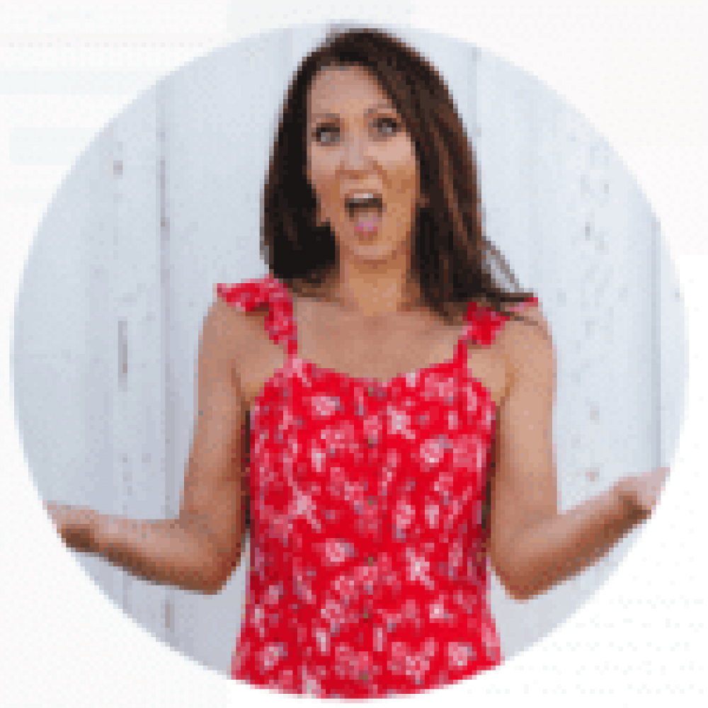 Woman in red floral dress expressing surprise with hands raised.